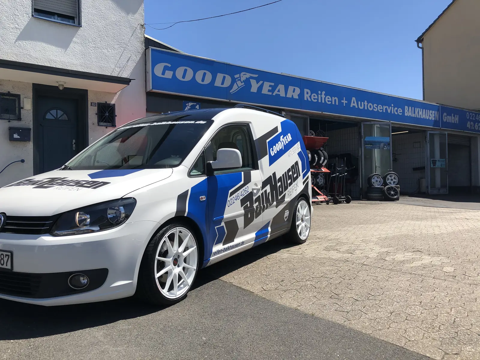 Werkstatt von Reifen u. Auto-Service Balkhausen an der Hauptstraße in Lohmar mit Firmenwagen im Balkhausen-Design
